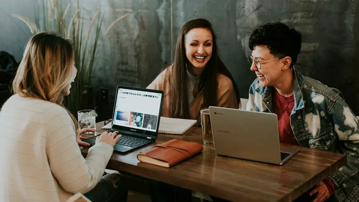 Building Maintenance: Three Smiling Women Collaborating at a Table