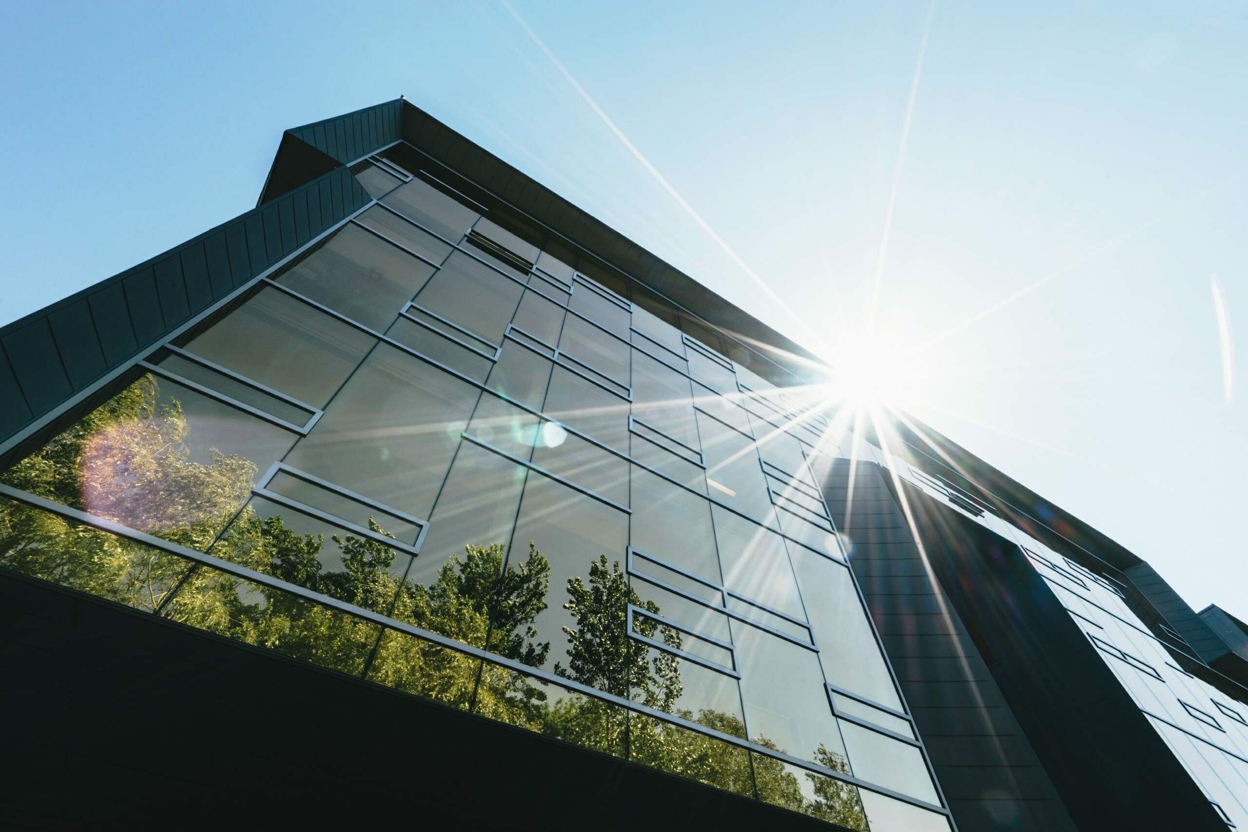 Building with a glass facade illuminated by sunlight.