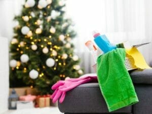 Christmas tree in the background with a section of a sofa and cleaning products in the foreground.