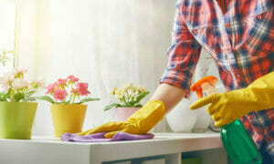 Individual cleaning a table adorned with fresh spring flowers.